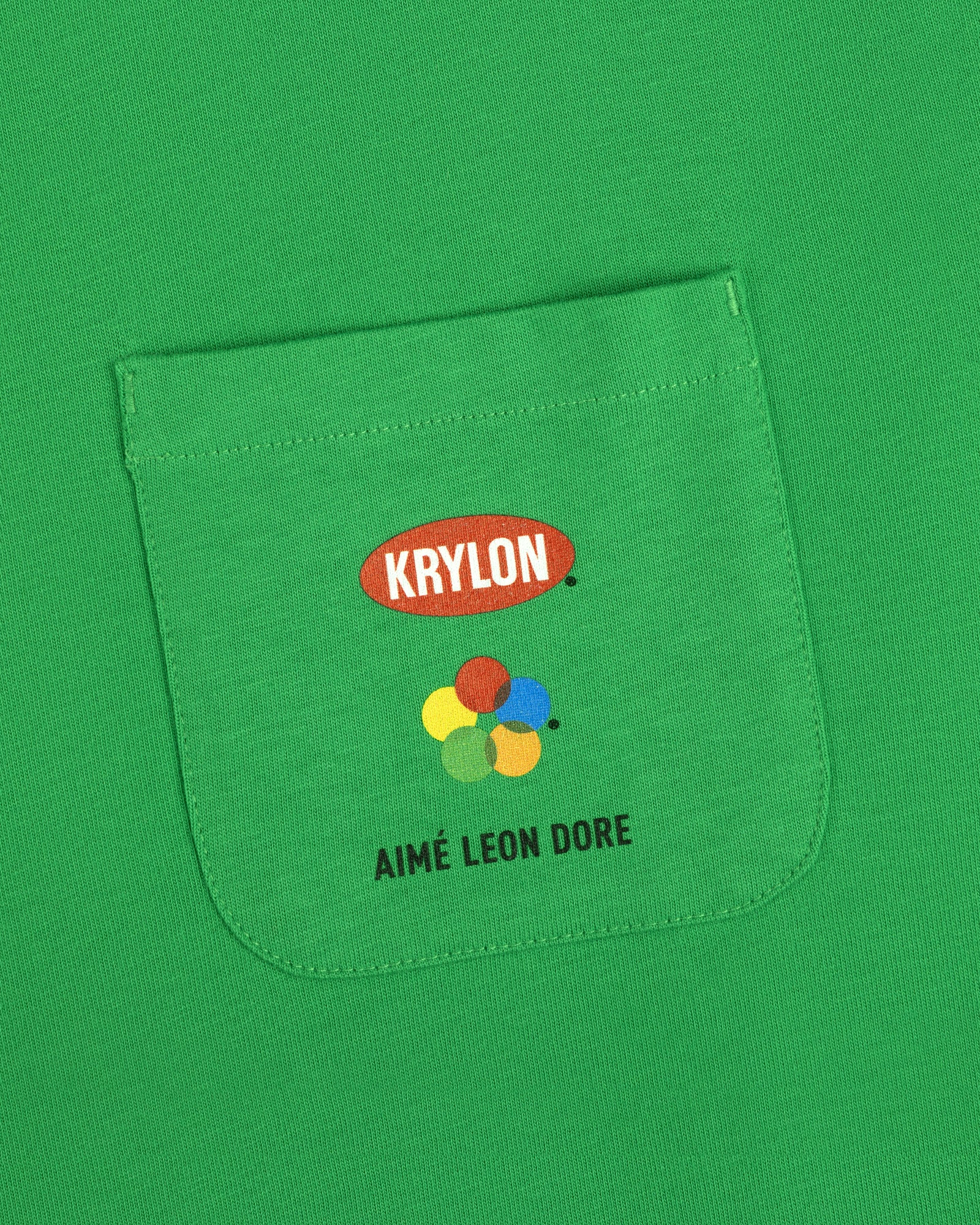 Krylon Pocket Tee: Green shirt with KRYLON logo, colorful paint splatters, and AIMÉ LEON DORE text below.