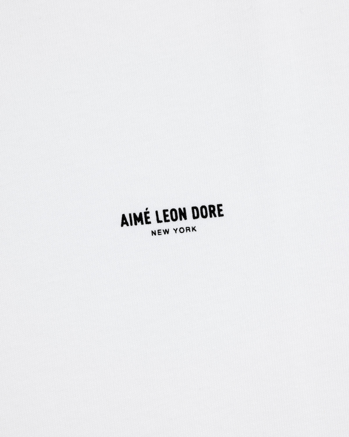 White Long-Sleeve Micro Logo Tee with small black "AIMÉ LEON DORE NEW YORK" text in the center.