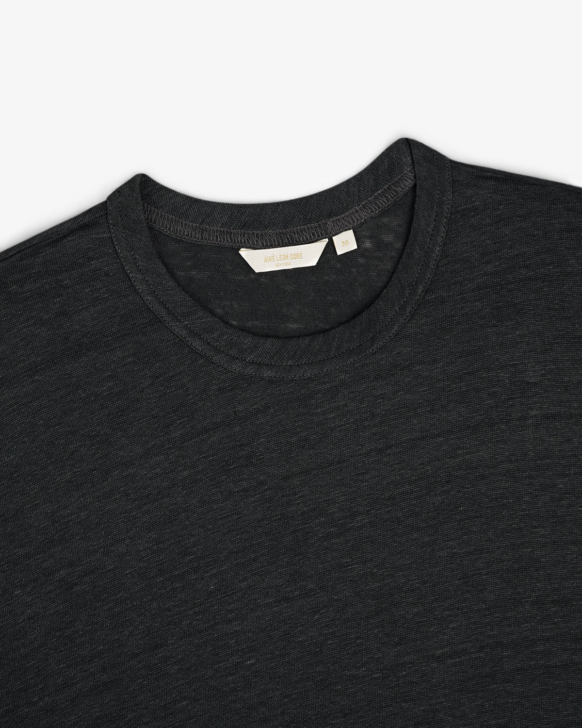 Linen Tee in dark gray, crew neck style, laid flat to display upper chest, collar, and inner neckline tag.