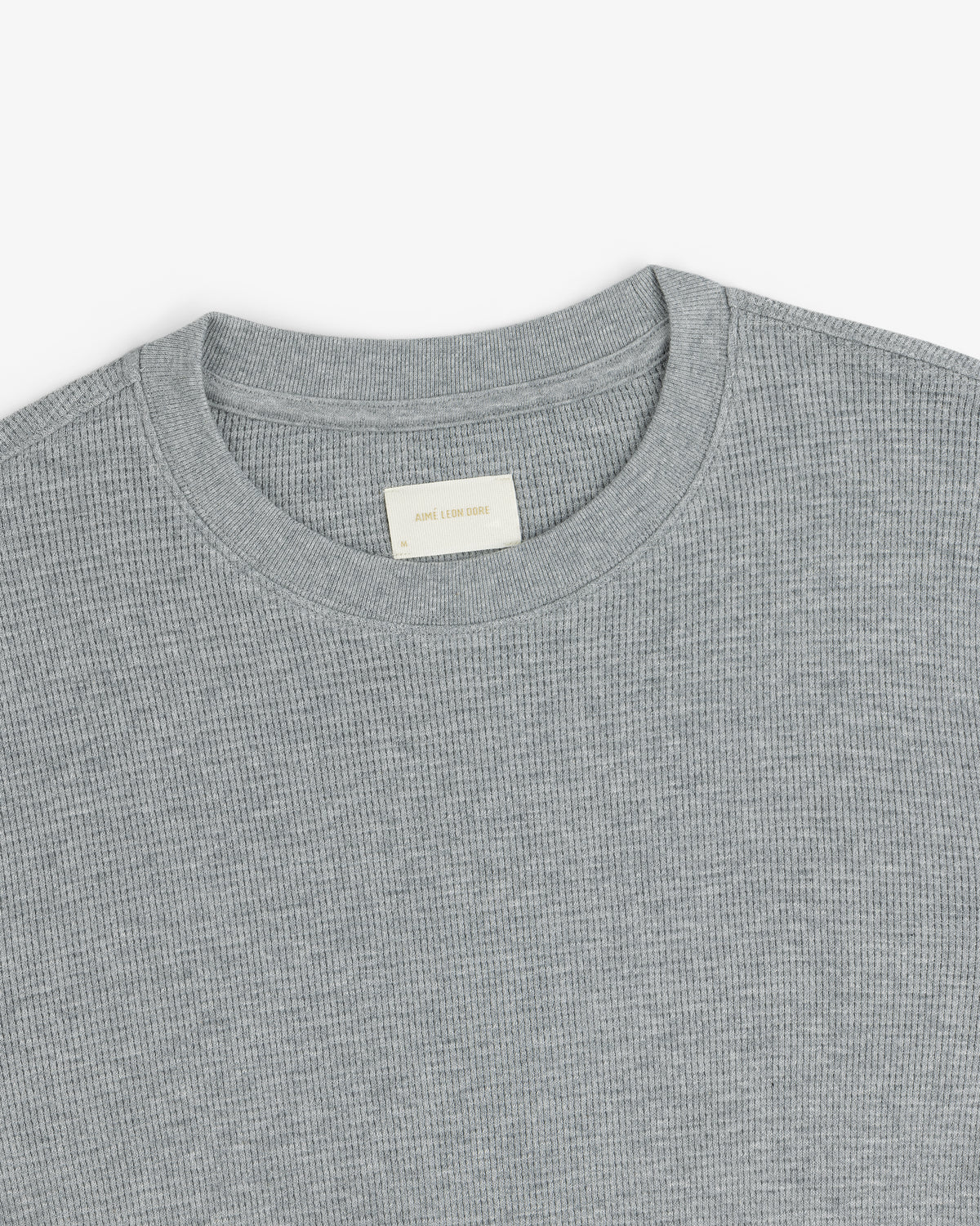 A close-up of a light gray Long-Sleeve Waffle Thermal with a ribbed crewneck and beige label inside the collar.