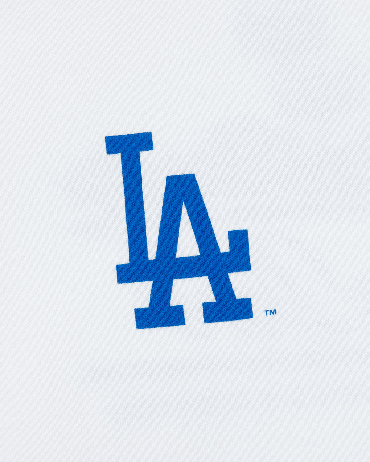 Blue LA logo on white tee, ALD / LA Dodgers Unisphere, celebrating the Los Angeles Dodgers baseball team.