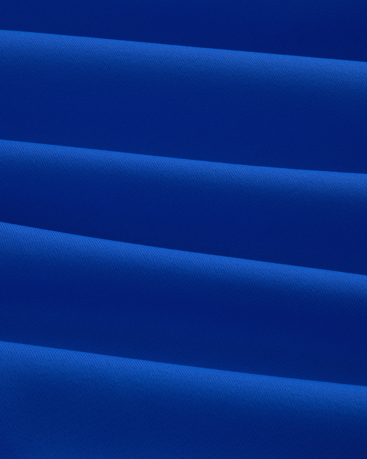 Close-up of evenly folded Short Sleeve Crest Rash Guard, forming horizontal ridges and shadows.