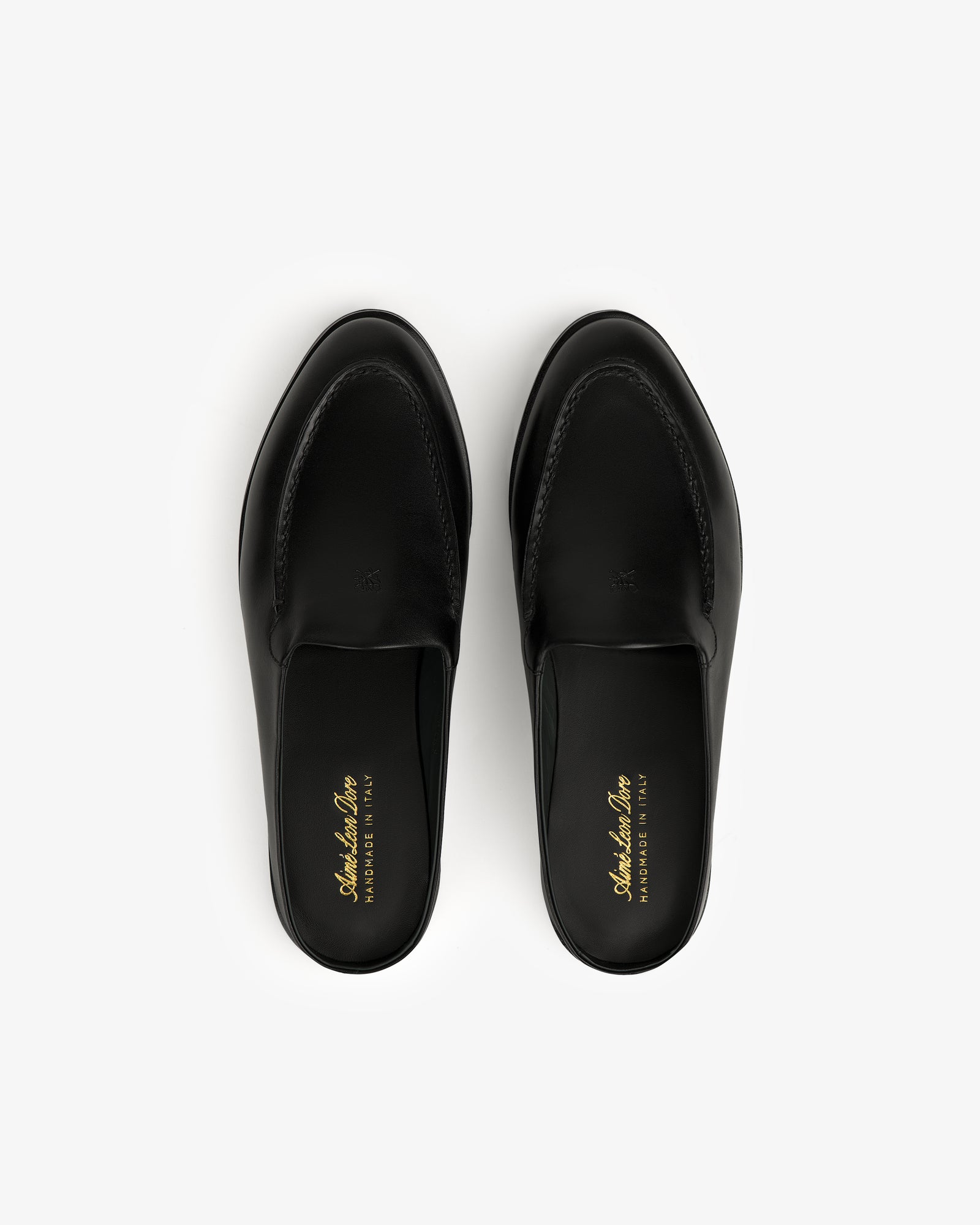 The Venetian Mule in black leather, slip-on loafers shown from above on a white background.