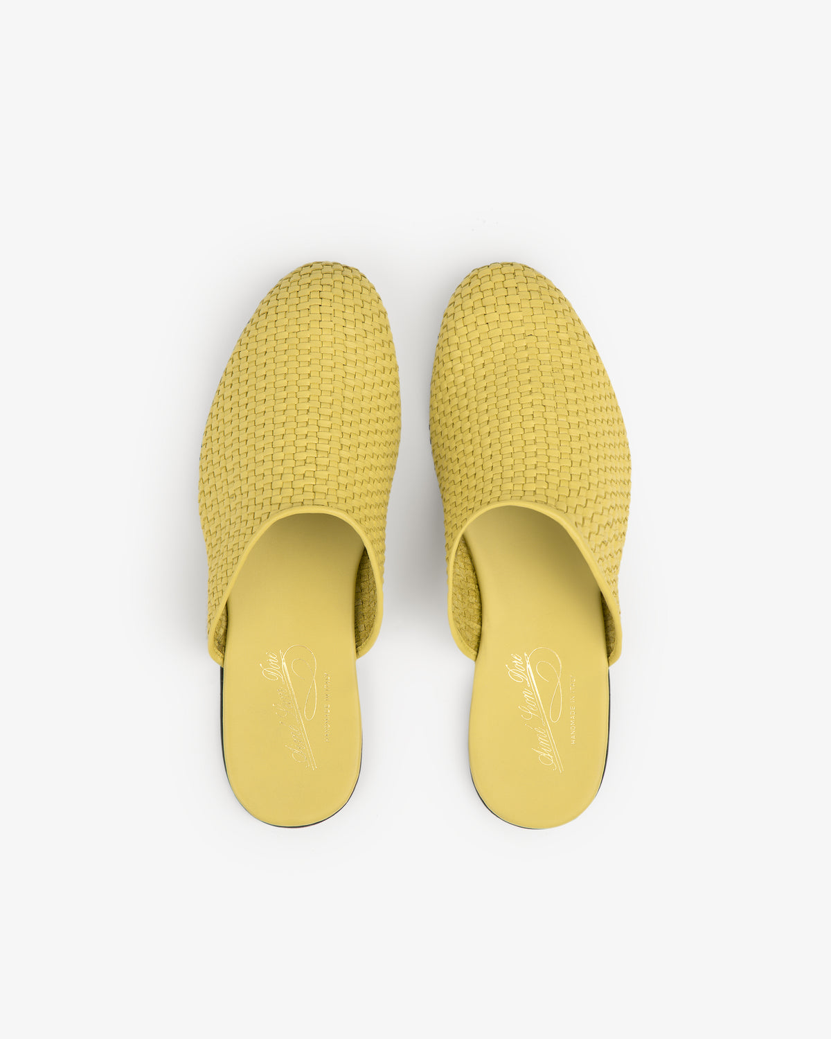 A pair of yellow Leather Raffia Mule slip-on shoes viewed from above on a white background.