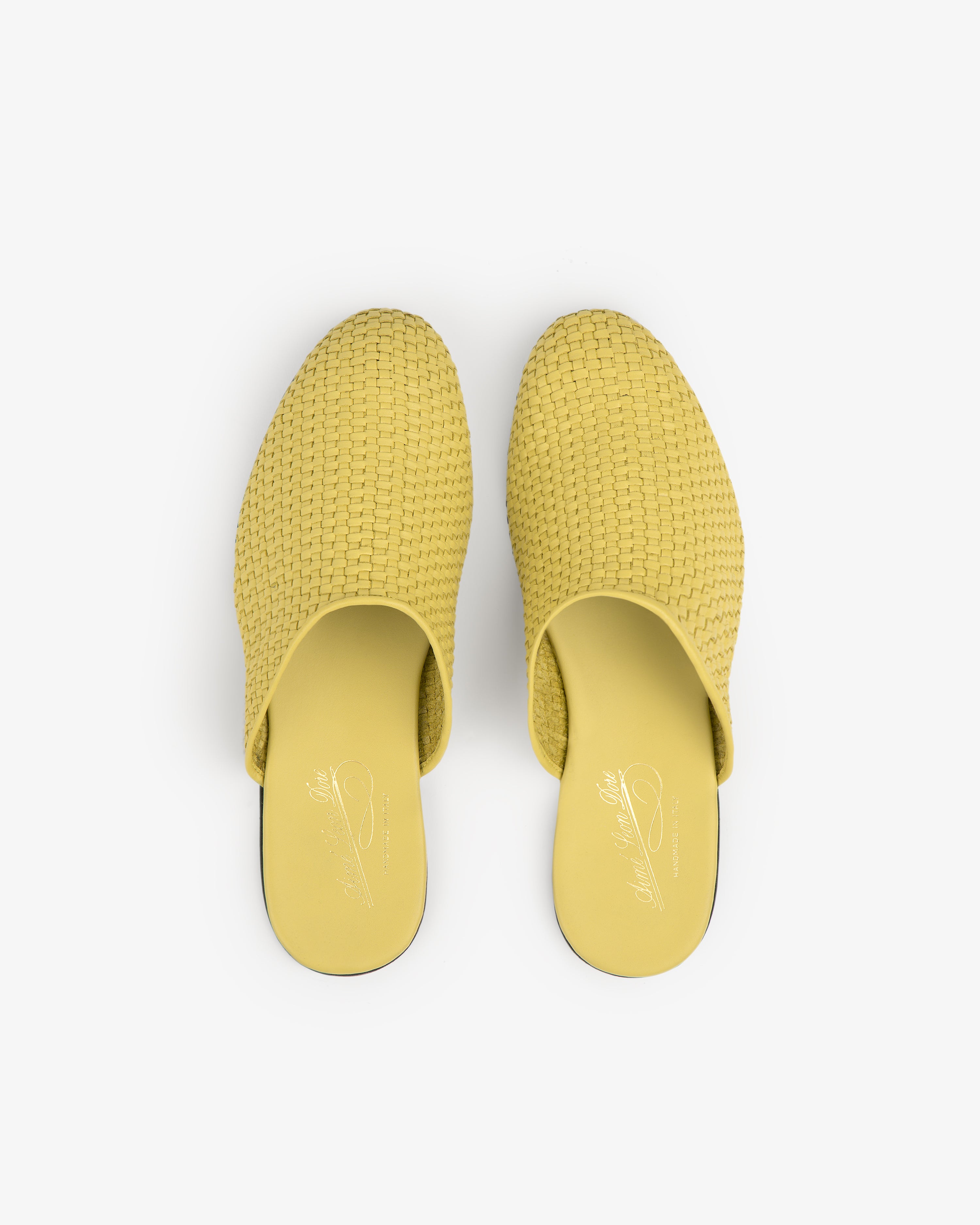 A pair of yellow Leather Raffia Mule slip-on shoes viewed from above on a white background.