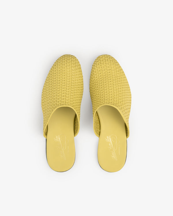 A pair of yellow Leather Raffia Mule slip-on shoes viewed from above on a white background.