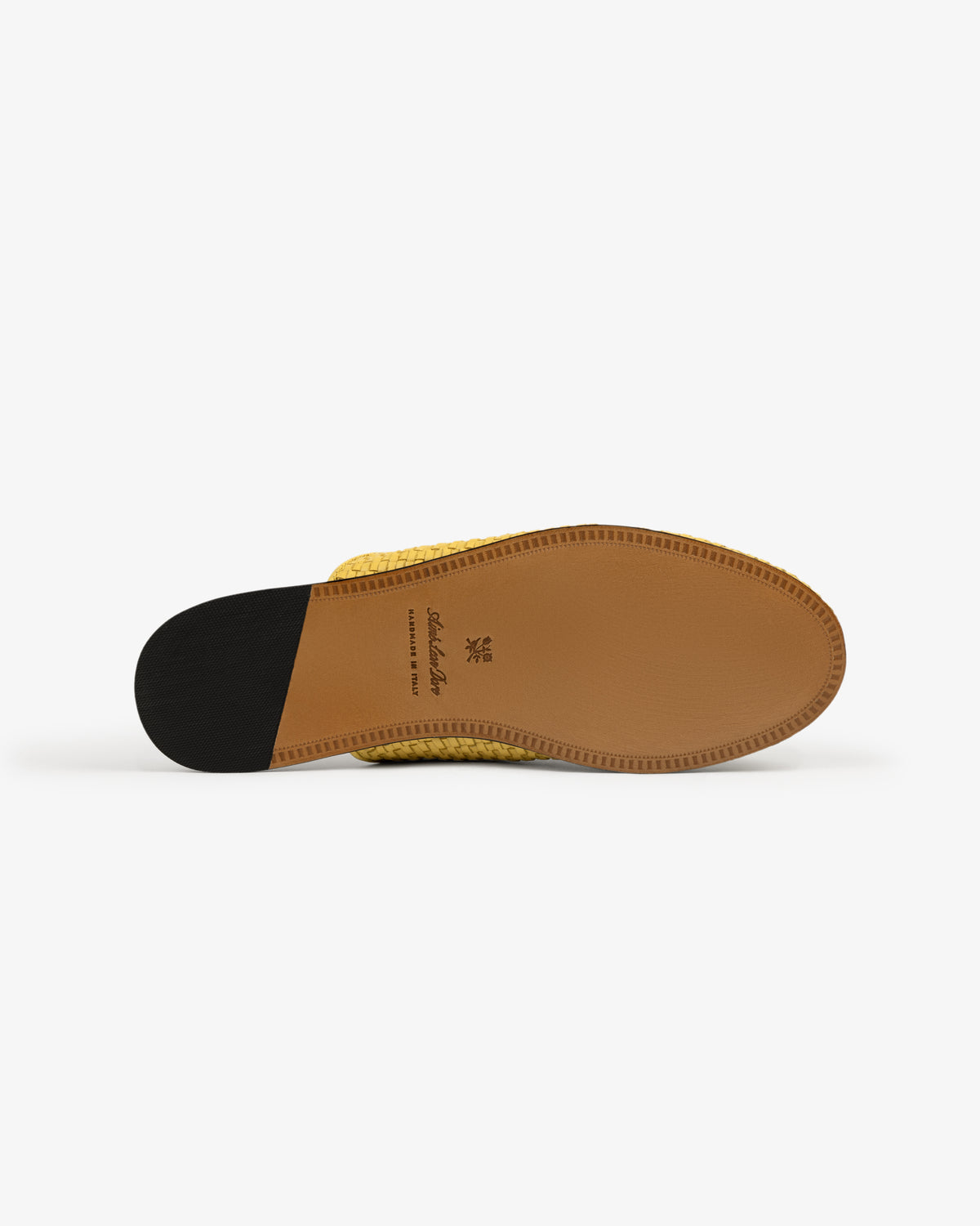 The underside of the Leather Raffia Mule shows its yellow woven upper, tan leather sole, and black heel on white.