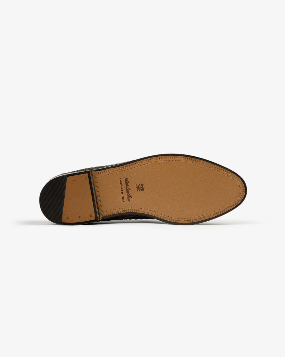 The sole of a Leather Raffia Loafer with a stacked heel and stitching, shown against a white background.