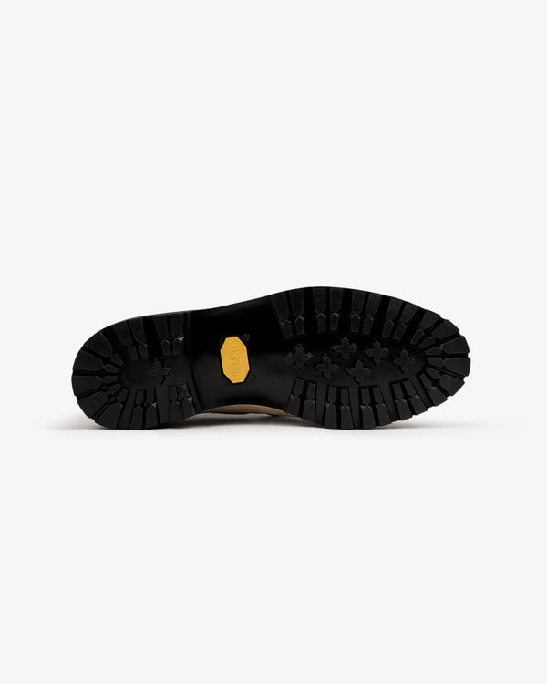 The Pápia Boat Shoe features a black, rugged outsole with deep treads and a yellow hexagonal logo in the center.