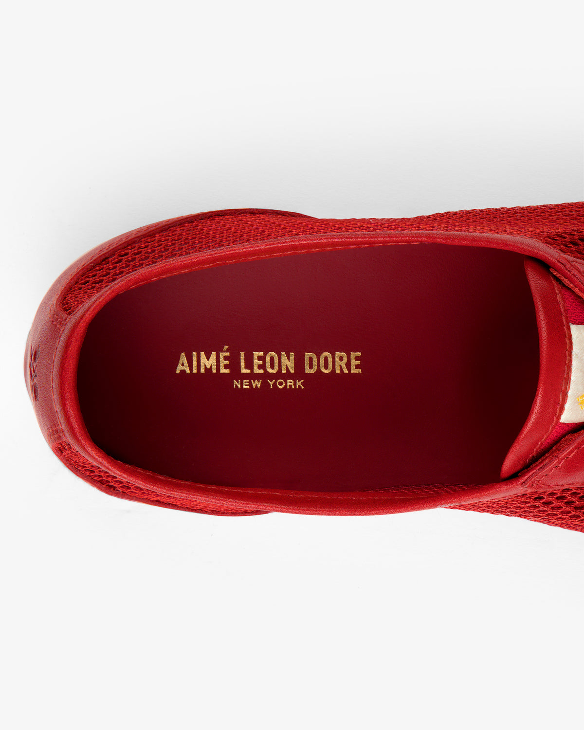 Top view of the Low Profile Mesh Trainer with AIMÉ LEON DORE NEW YORK in gold on the red insole.