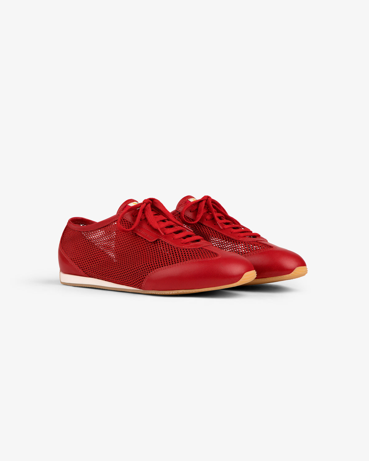 The Low Profile Mesh Trainer: red lace-up sneakers with mesh sides and tan rubber soles on a white background.