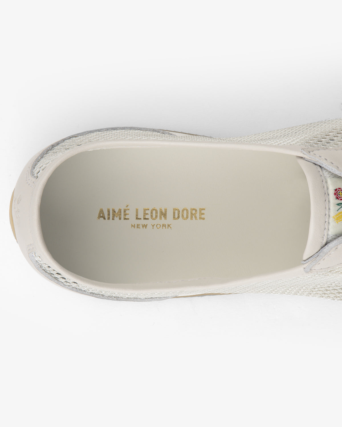 Top view of the Low Profile Mesh Trainer, a white sneaker with AIMÉ LEON DORE NEW YORK gold text on the insole.
