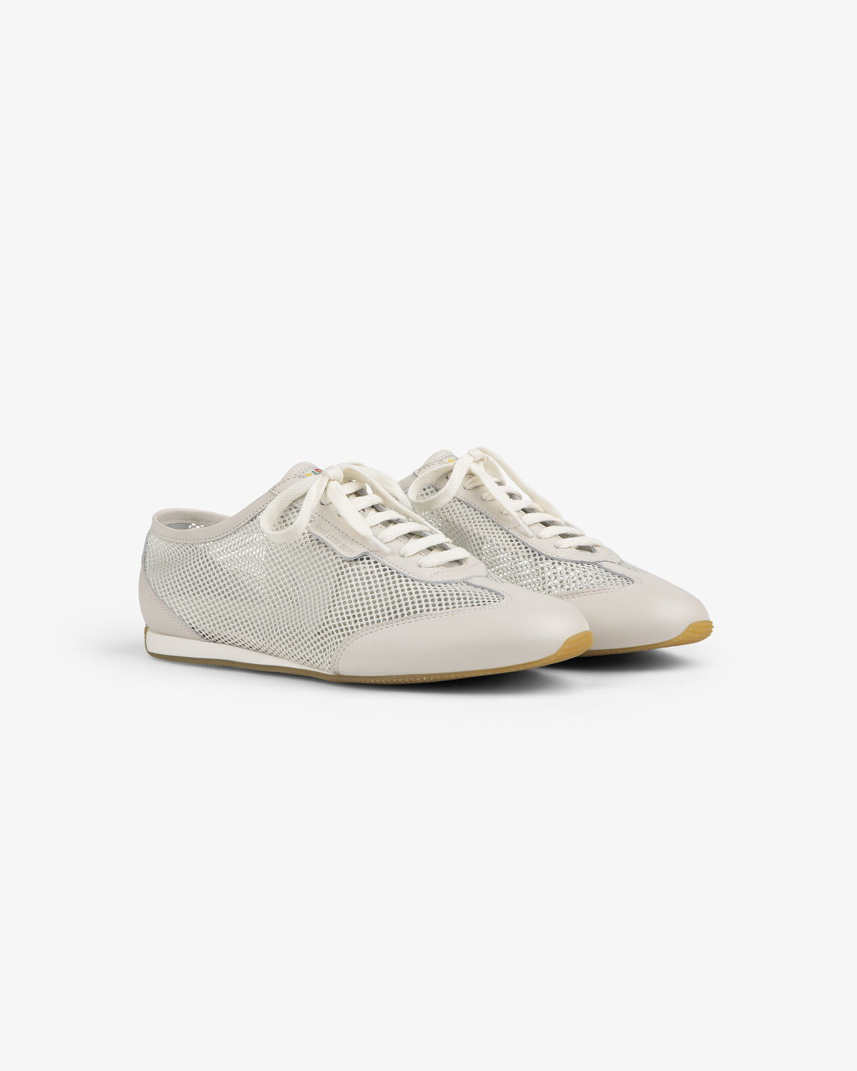 Low Profile Mesh Trainer: white mesh sneakers with lace-up fronts and beige soles, shown on a plain white background.