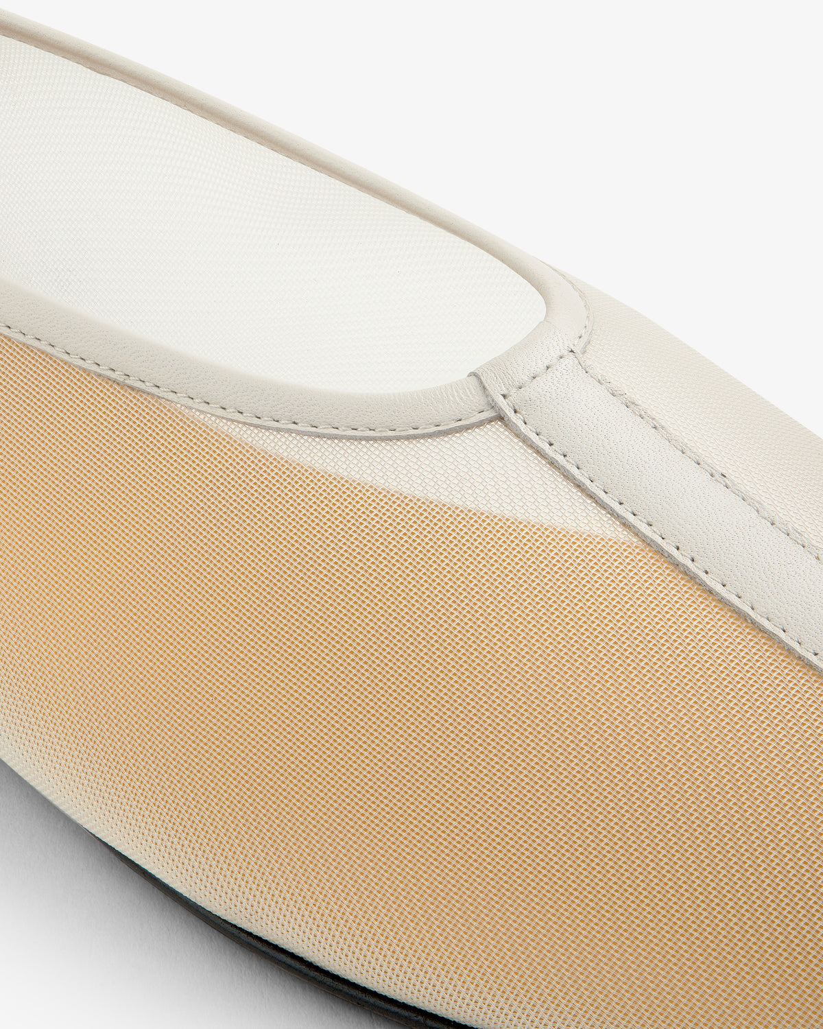 Close-up of the Mesh Ballet Flat, a beige and white slip-on with a textured fabric upper and smooth trim.