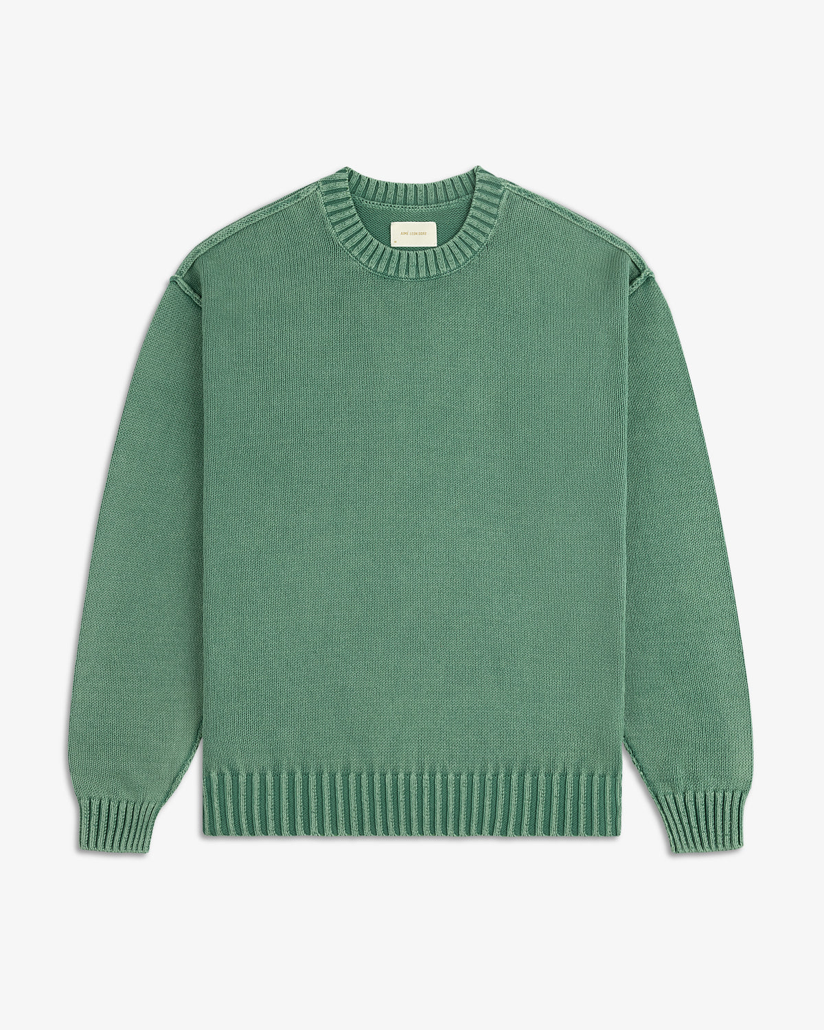 The Washed Inside Out Sweater is a plain green, long-sleeve crew-neck with ribbed cuffs, collar, and hem on white background.