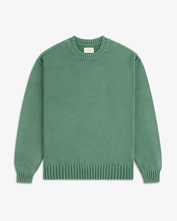 The Washed Inside Out Sweater is a plain green, long-sleeve crew-neck with ribbed cuffs, collar, and hem on white background.