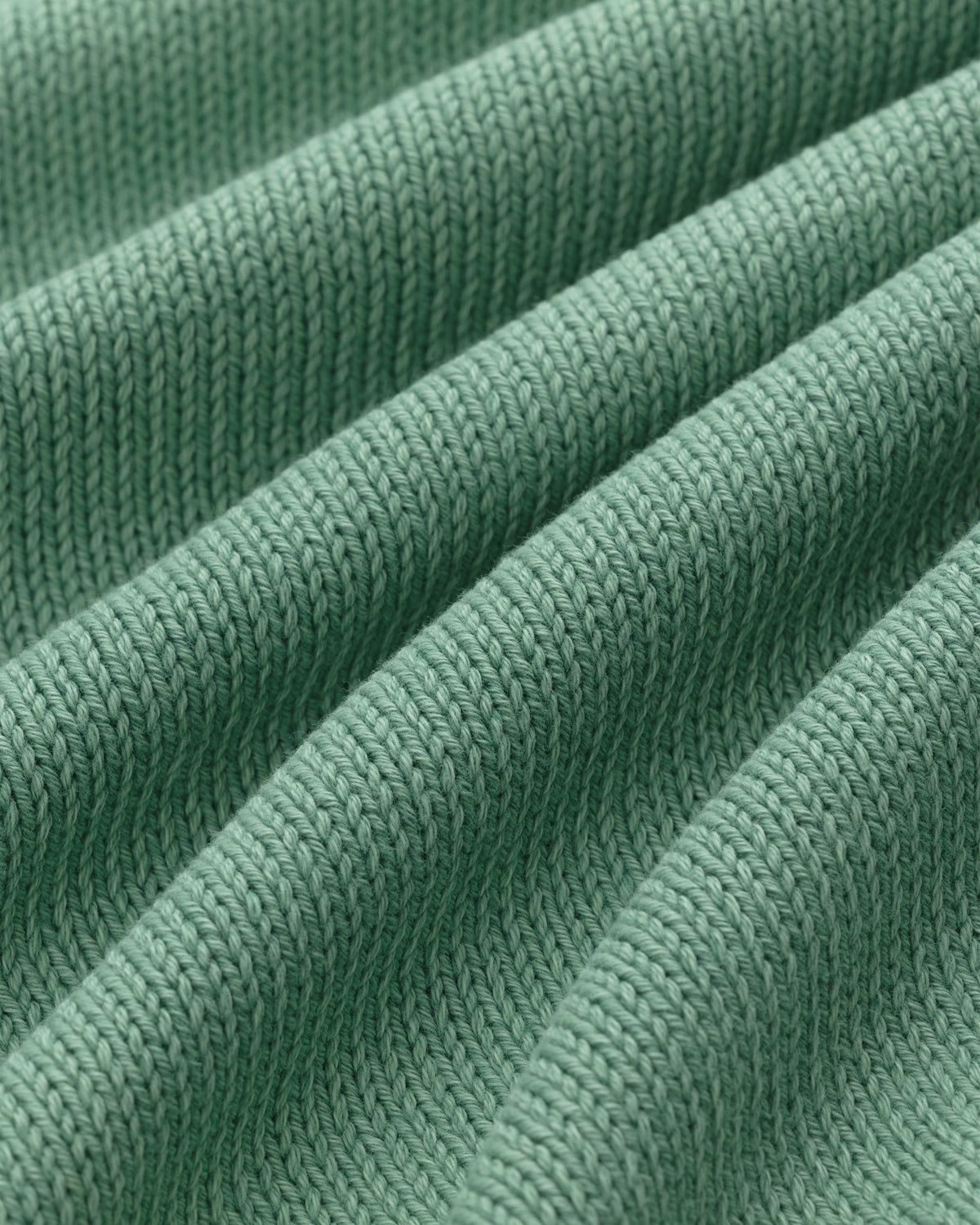 Close-up of the Washed Inside Out Sweater's green ribbed knit with textured, diagonal raised ridges.