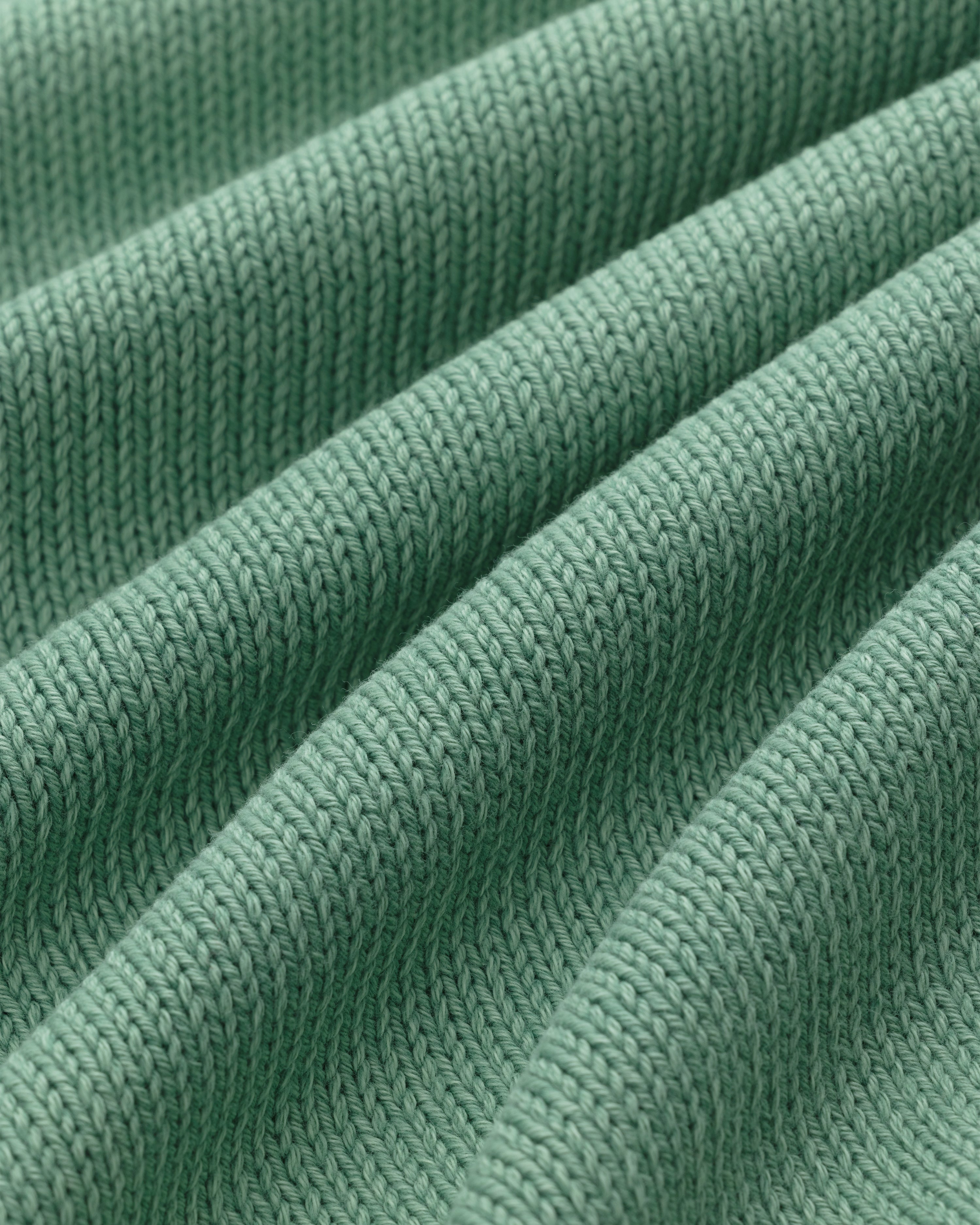 Close-up of the Washed Inside Out Sweater's green ribbed knit with textured, diagonal raised ridges.