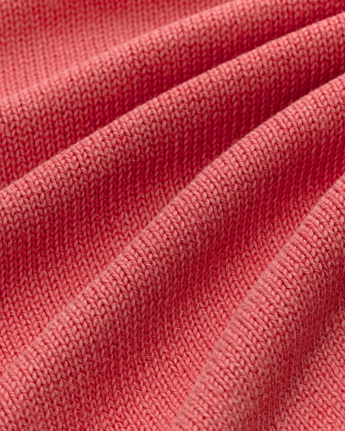 Close-up of the Washed Inside Out Sweater's ribbed pink knit fabric, showing its texture and soft folds.