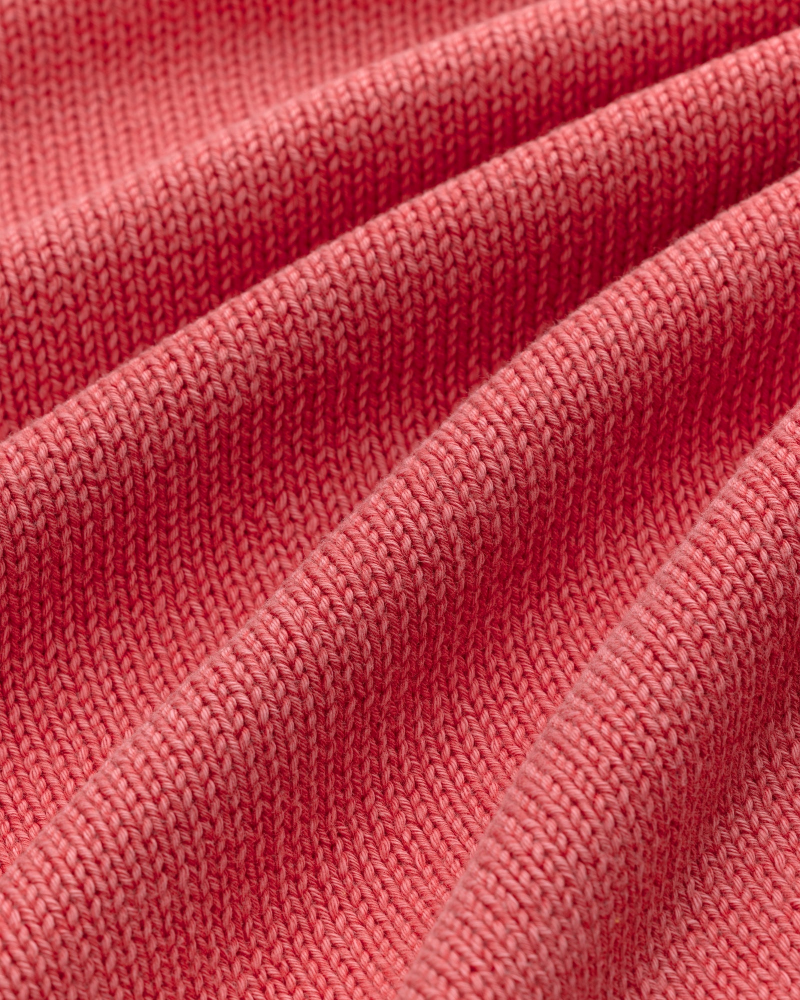 Close-up of the Washed Inside Out Sweater's ribbed pink knit fabric, showing its texture and soft folds.