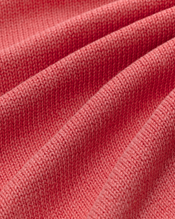 Close-up of the Washed Inside Out Sweater's ribbed pink knit fabric, showing its texture and soft folds.