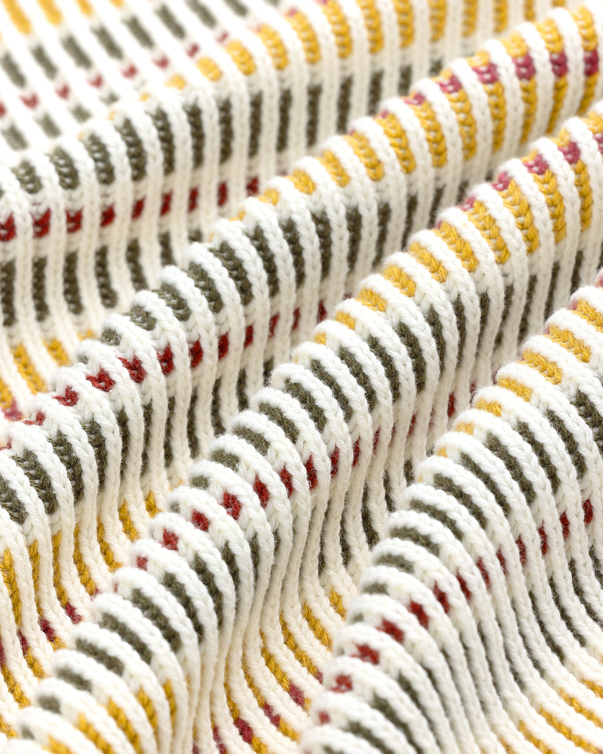 Close-up of Multi Color Knit Track Sweater fabric with raised white ridges and yellow, green, and red stripes.