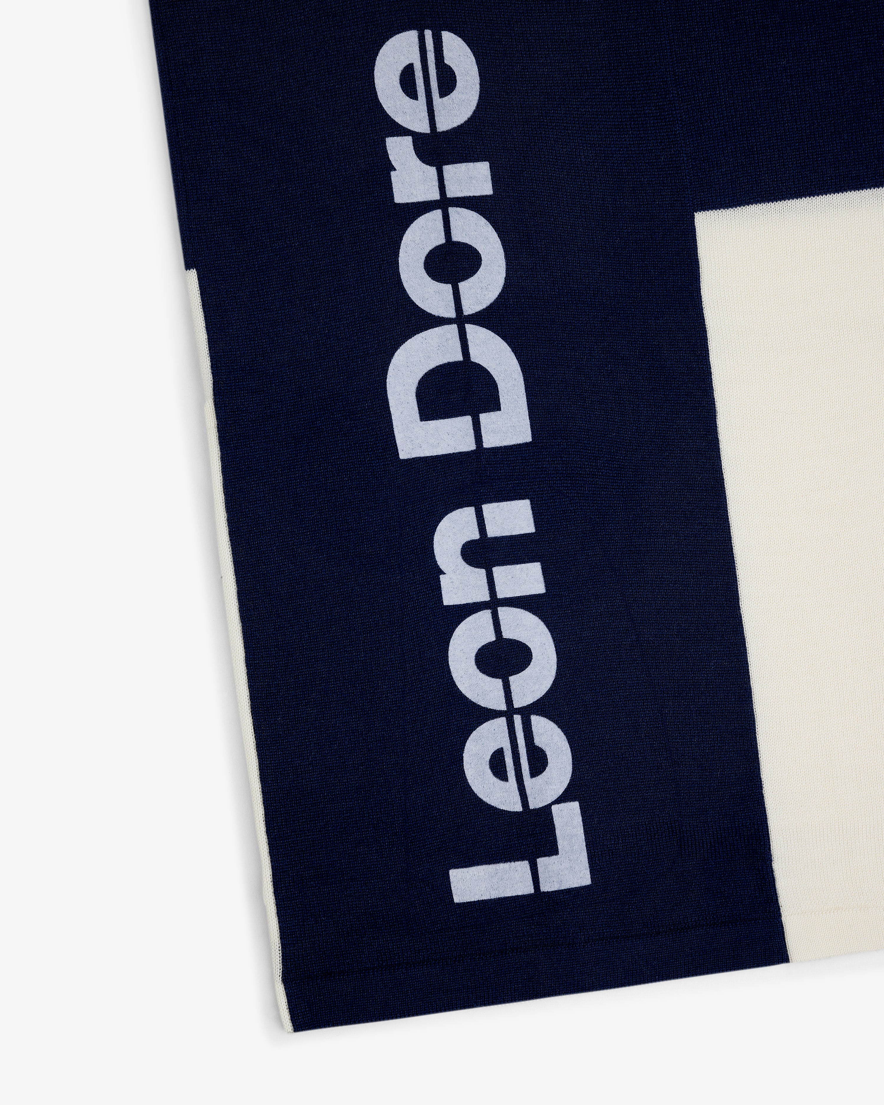 Navy Merino Wool Cycling Jersey with large white Leon Dore print beside a cream-colored section.