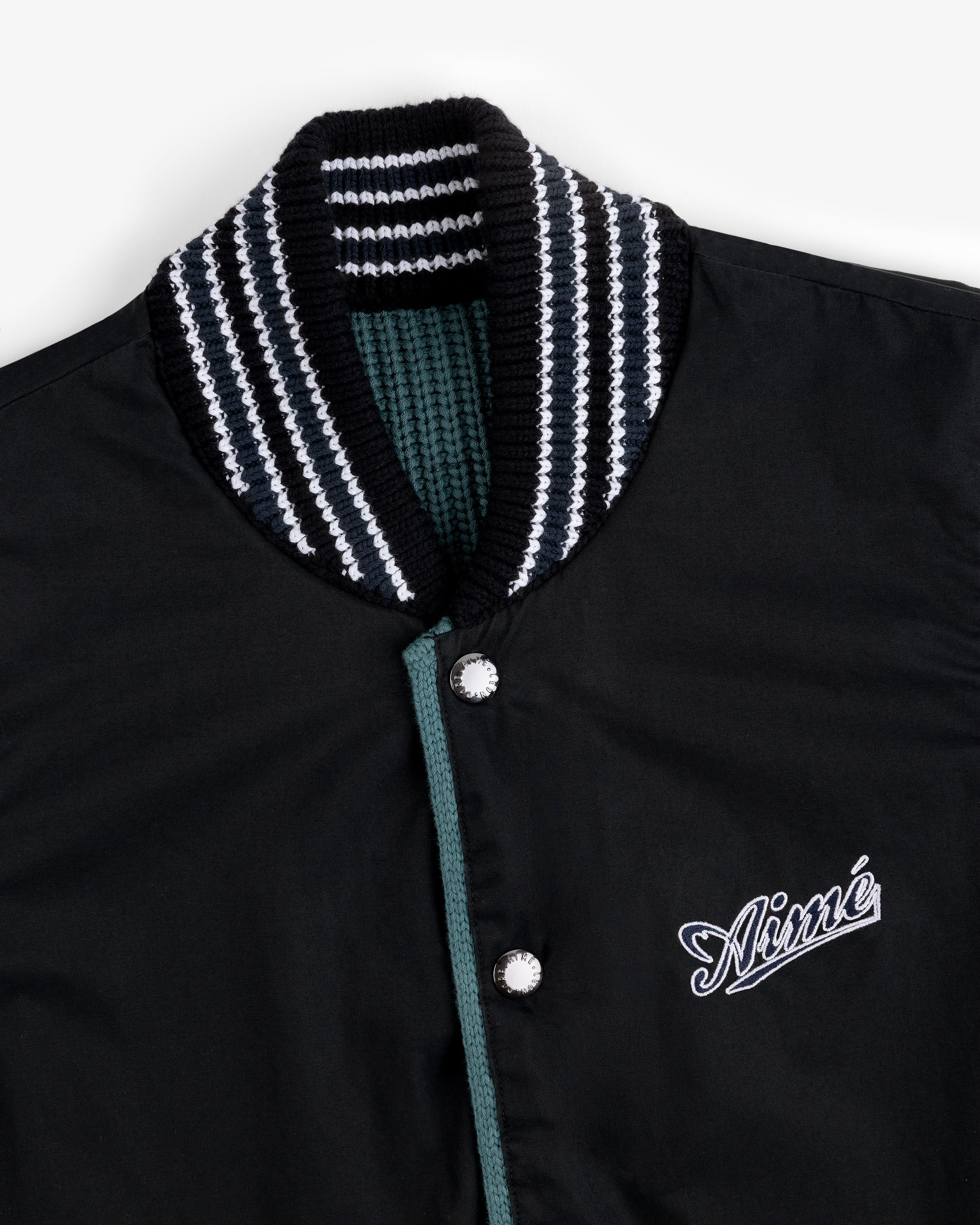 Reversible Knit Bomber Jacket with striped ribbed collar and Aimé embroidered on the chest in white script.
