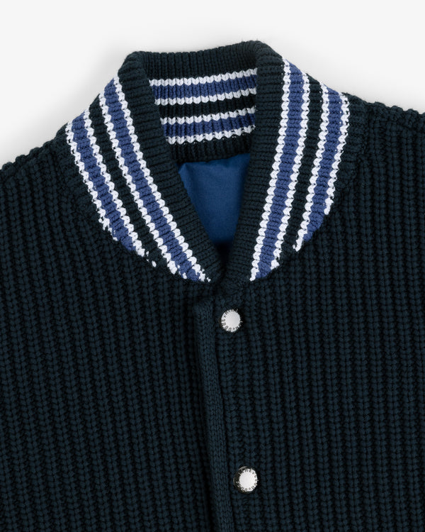 Close-up of a Reversible Knit Bomber Jacket with a textured black finish, striped collar, and silver snap buttons.