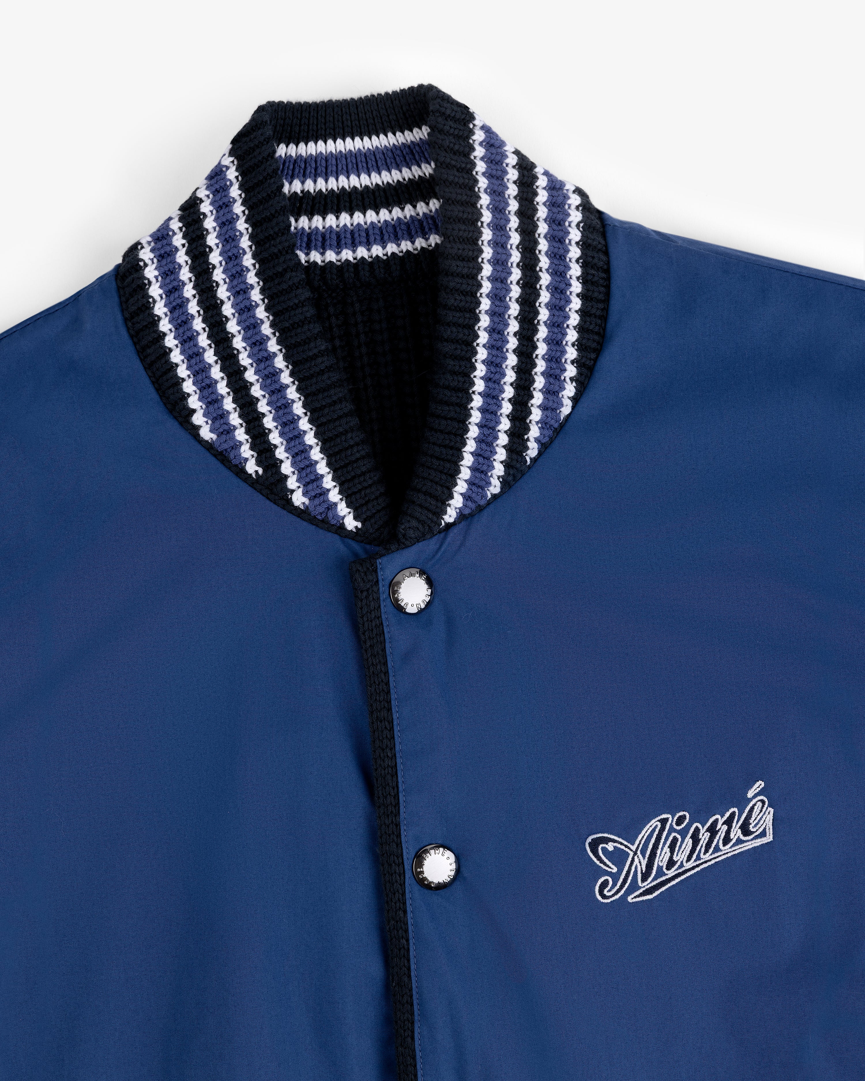 Reversible Knit Bomber Jacket with striped ribbed collar, snap buttons, and cursive Aimé logo on the chest.