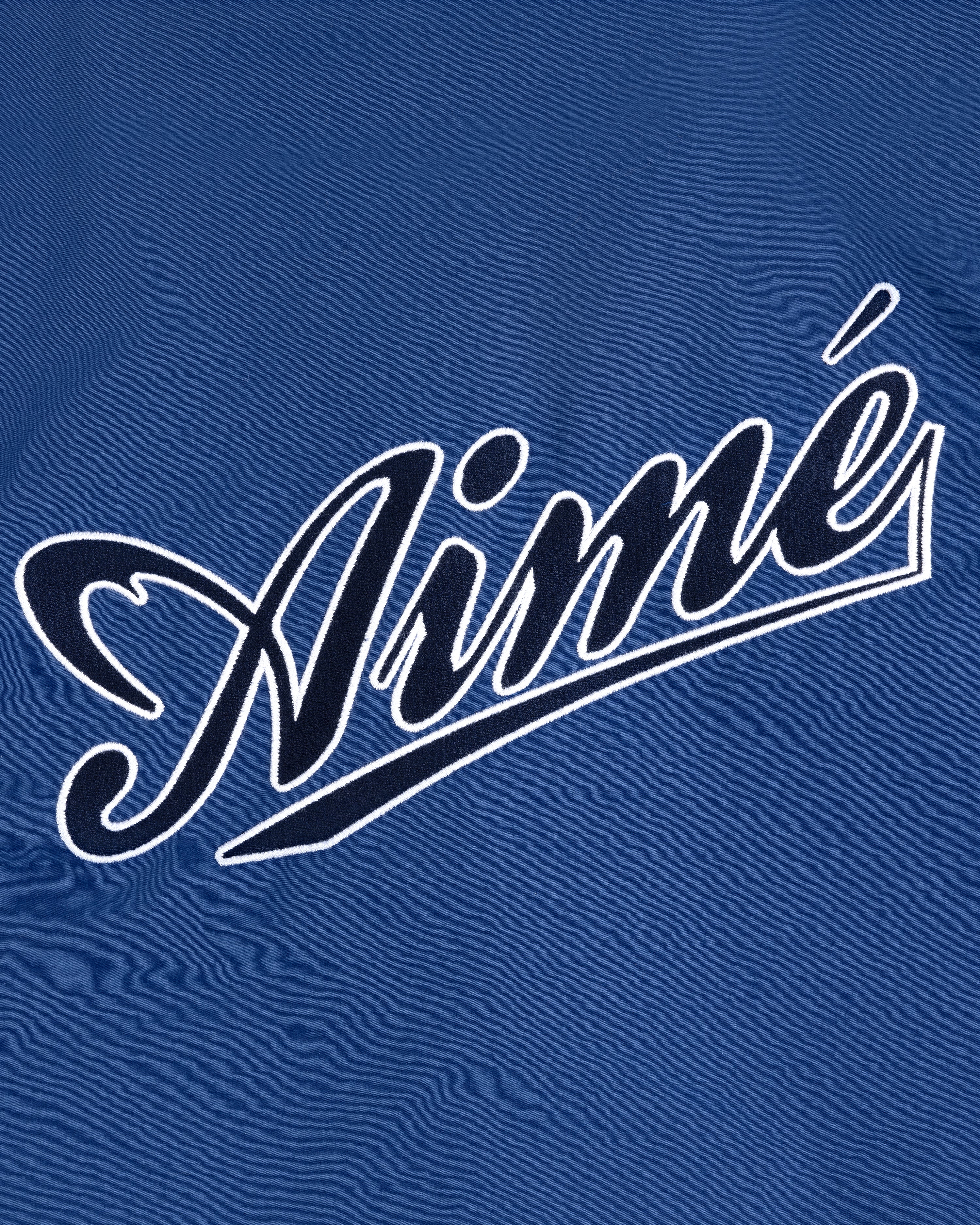 Blue Reversible Knit Bomber Jacket featuring "Aimé" in white cursive script across the center.