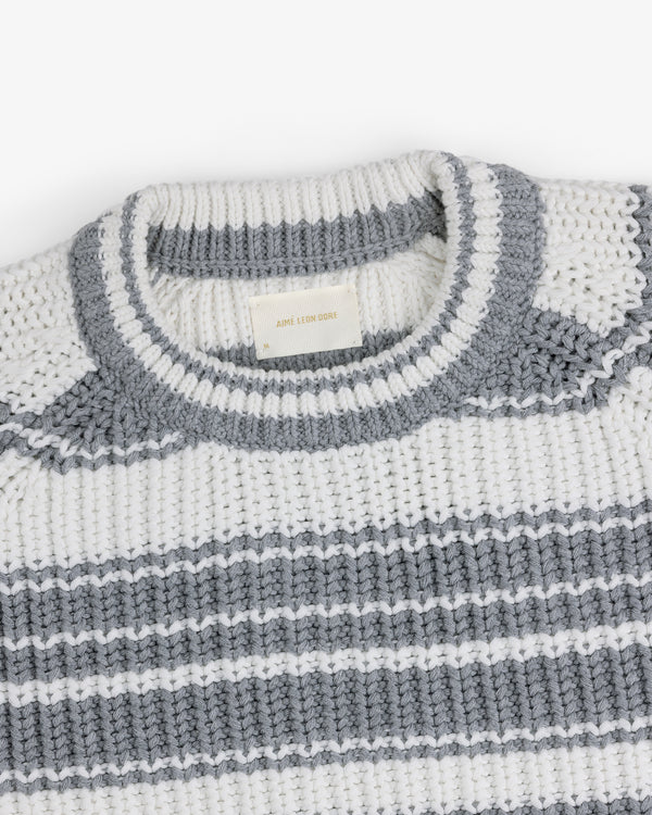 Striped Crewneck Sweater in white with gray stripes and a gray-trimmed neckline, displayed folded.