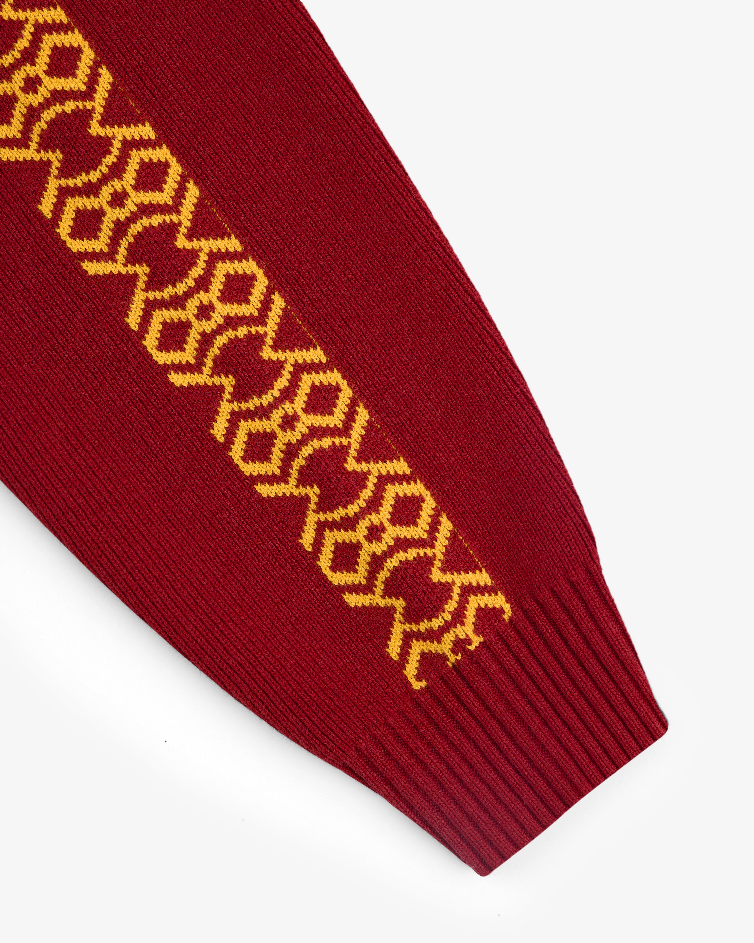 Knit Sport Pullover in red with yellow geometric sleeve pattern, displayed on a white background.