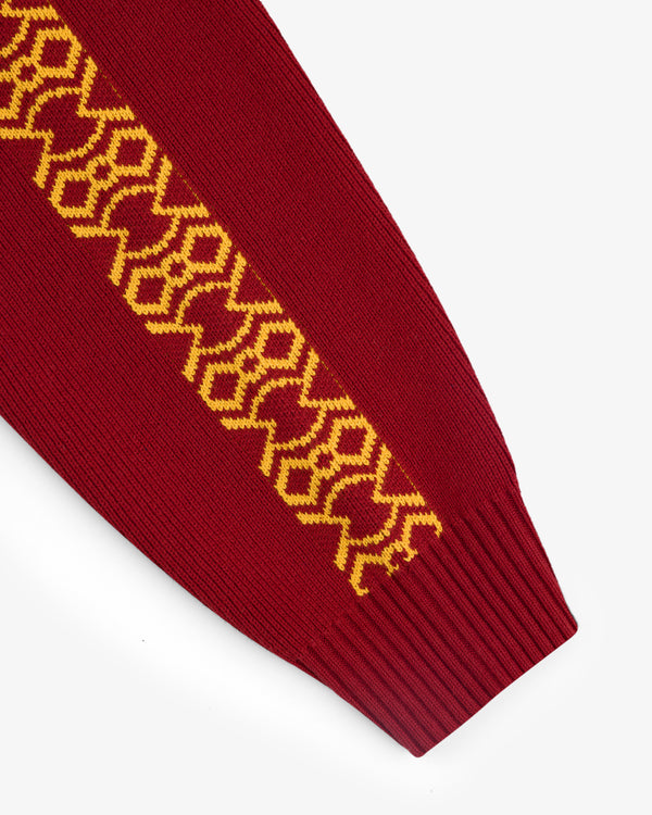 Knit Sport Pullover in red with yellow geometric sleeve pattern, displayed on a white background.
