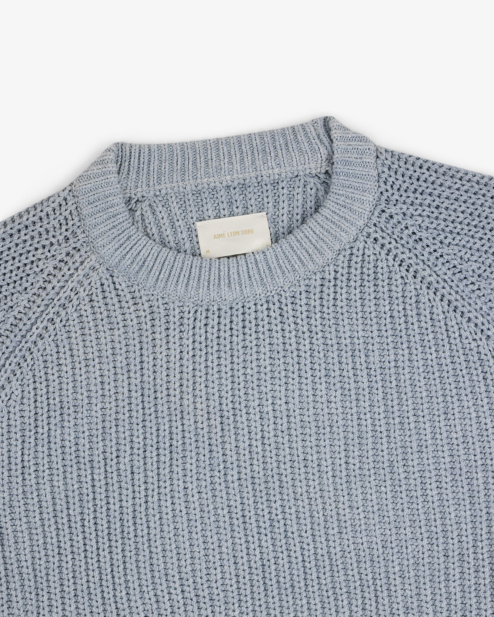 Knit Denim Crewneck Sweater with a ribbed neckline and textured pattern, shown on a white background.