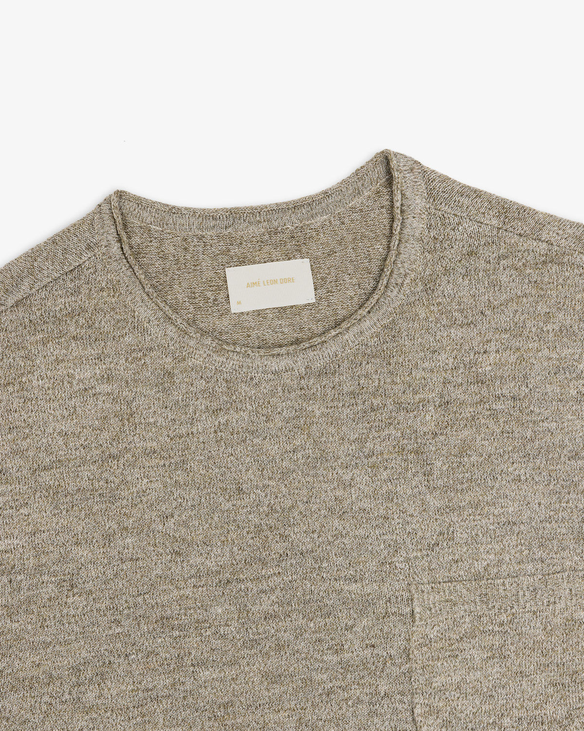 A close-up of a light gray Long-Sleeve Knit Pocket Tee with a visible beige label inside the collar.