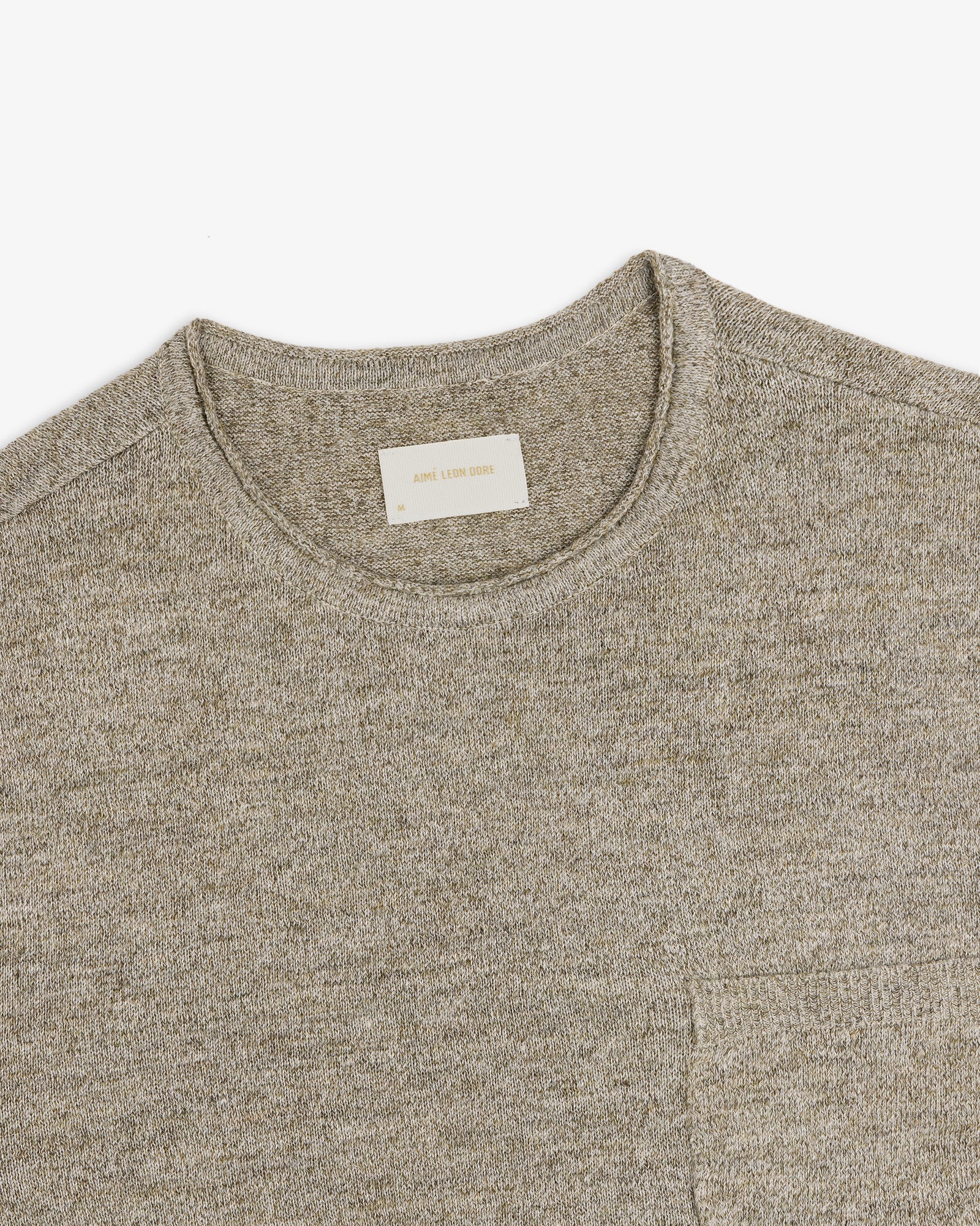 A close-up of a light gray Long-Sleeve Knit Pocket Tee with a visible beige label inside the collar.
