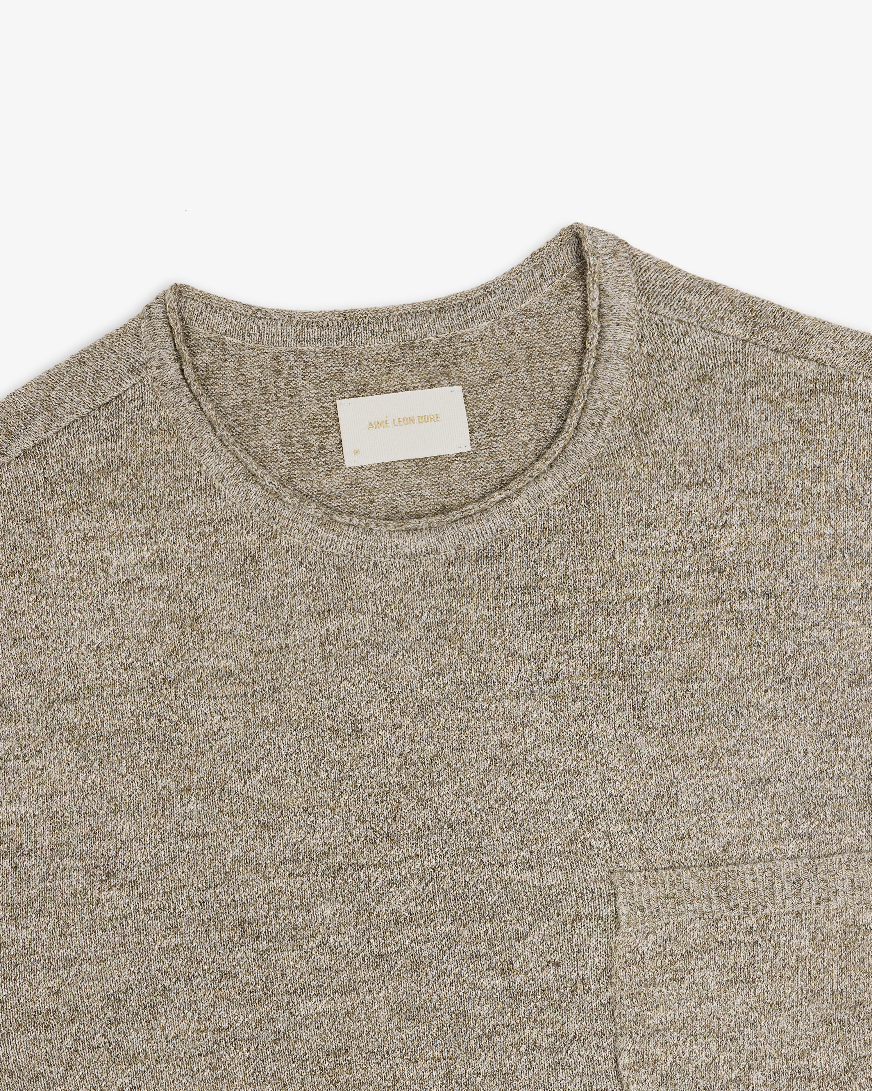 A close-up of a light gray Long-Sleeve Knit Pocket Tee with a visible beige label inside the collar.