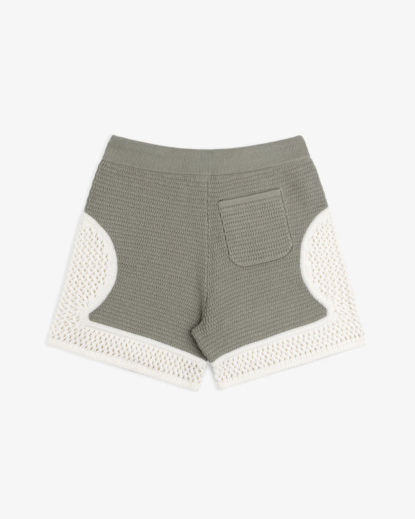 Knit Court Short in green with a back pocket and white crochet trim on sides and hem, shown on a white background.