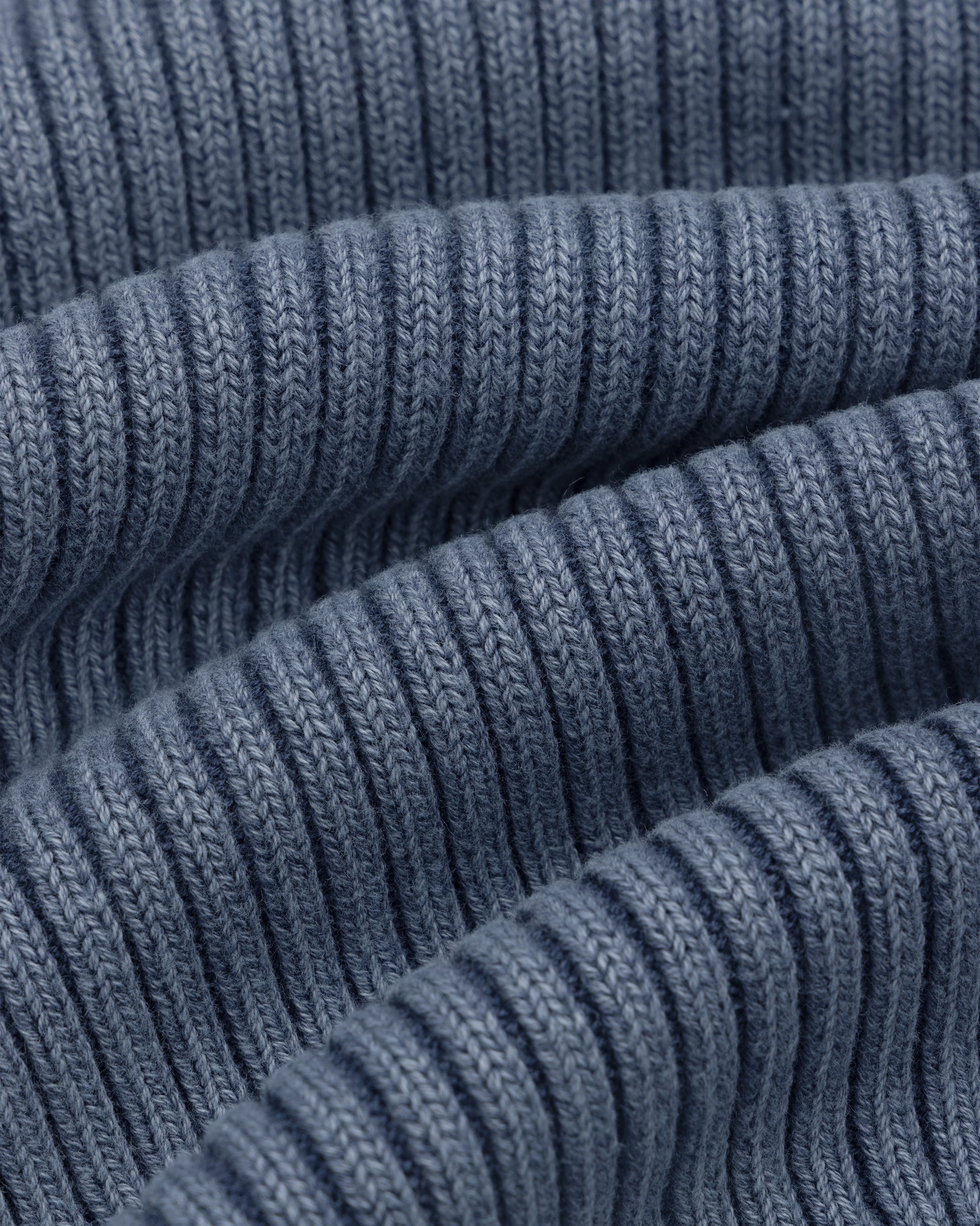 Close-up of Stone Washed Knit Tank Top in blue, showing ribbed fabric with wavy folds and detailed stitching.