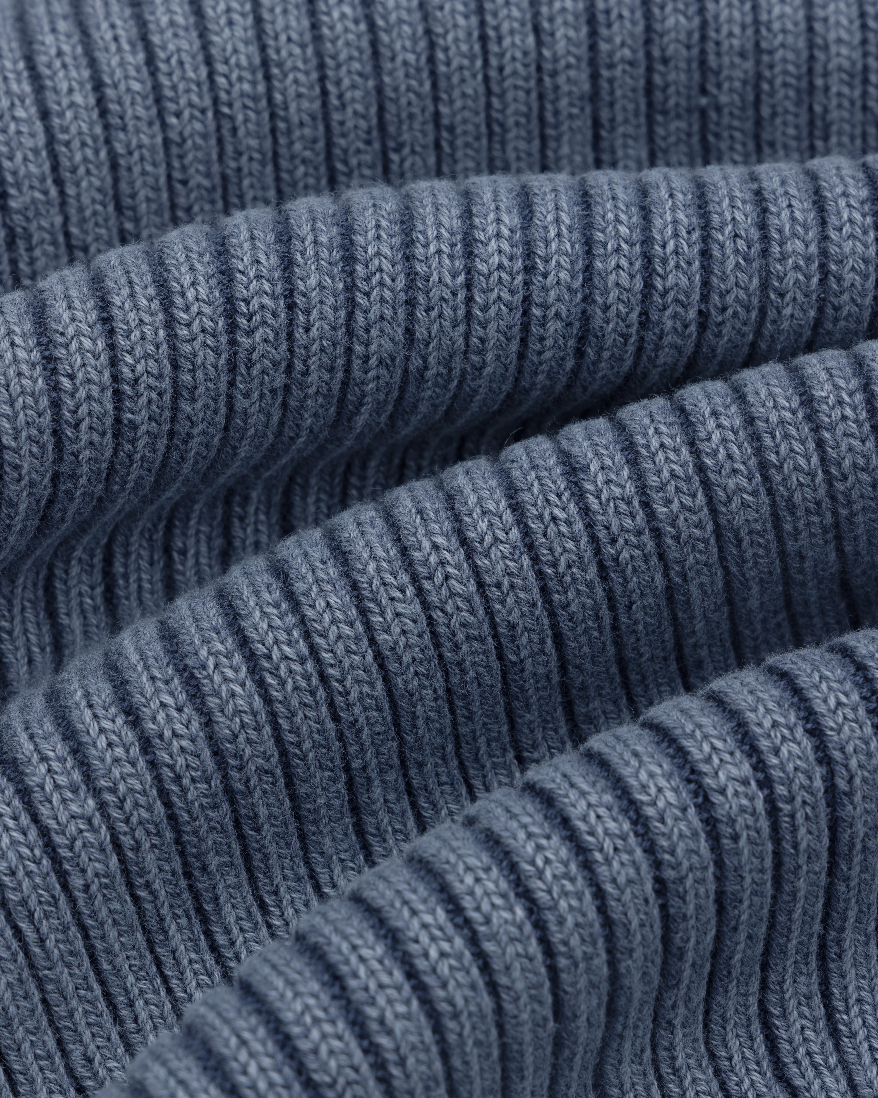 Close-up of Stone Washed Knit Tank Top in blue, showing ribbed fabric with wavy folds and detailed stitching.