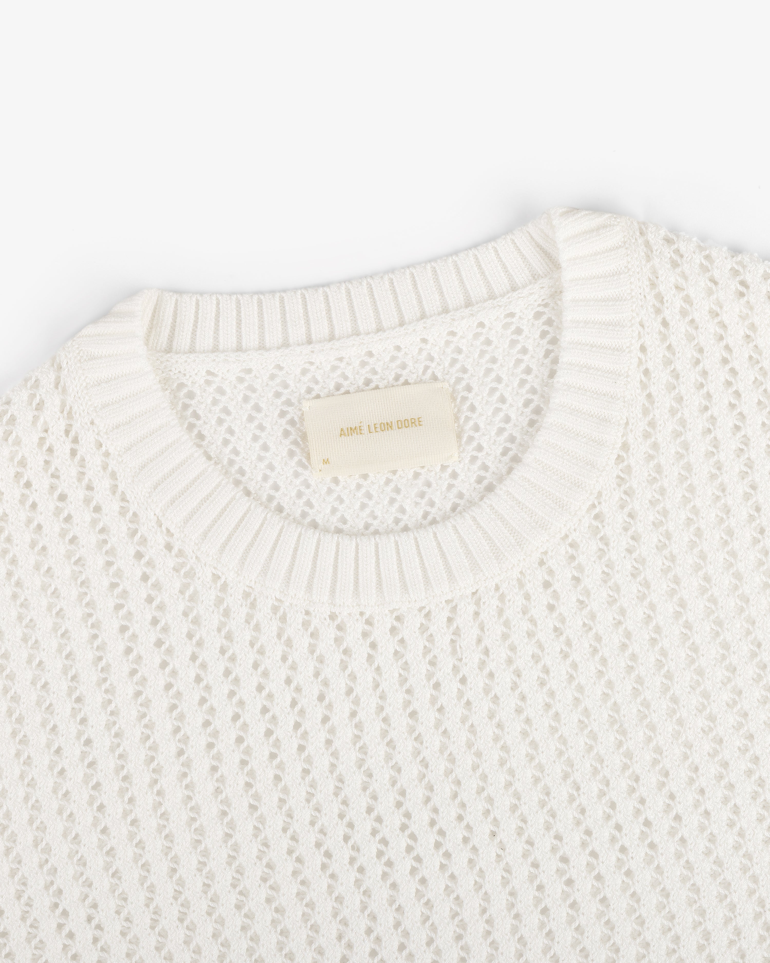Fassianos "Rendez-Vous" Crewneck Sweater—white knit with open weave, ribbed neckline, and beige Aimé Leon Dore label.