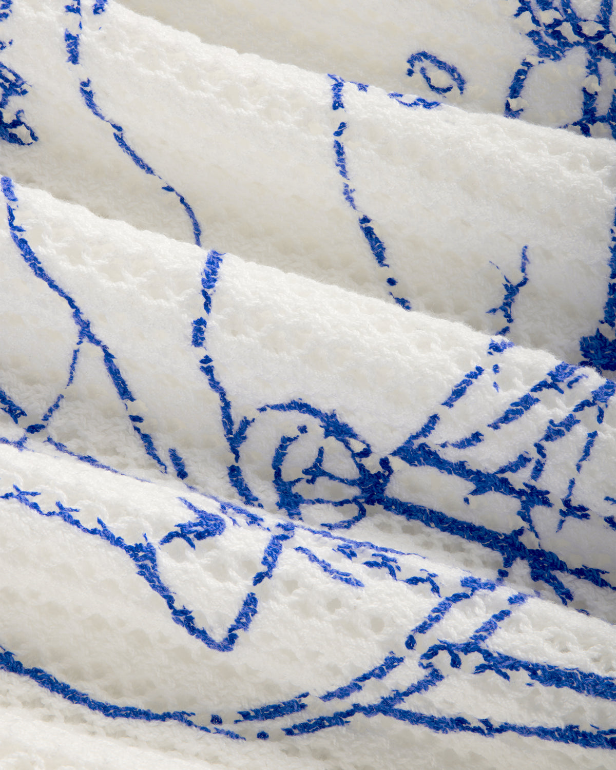 Close-up of Fassianos "Rendez - Vous" Crewneck Sweater's textured white fabric with abstract blue lines.