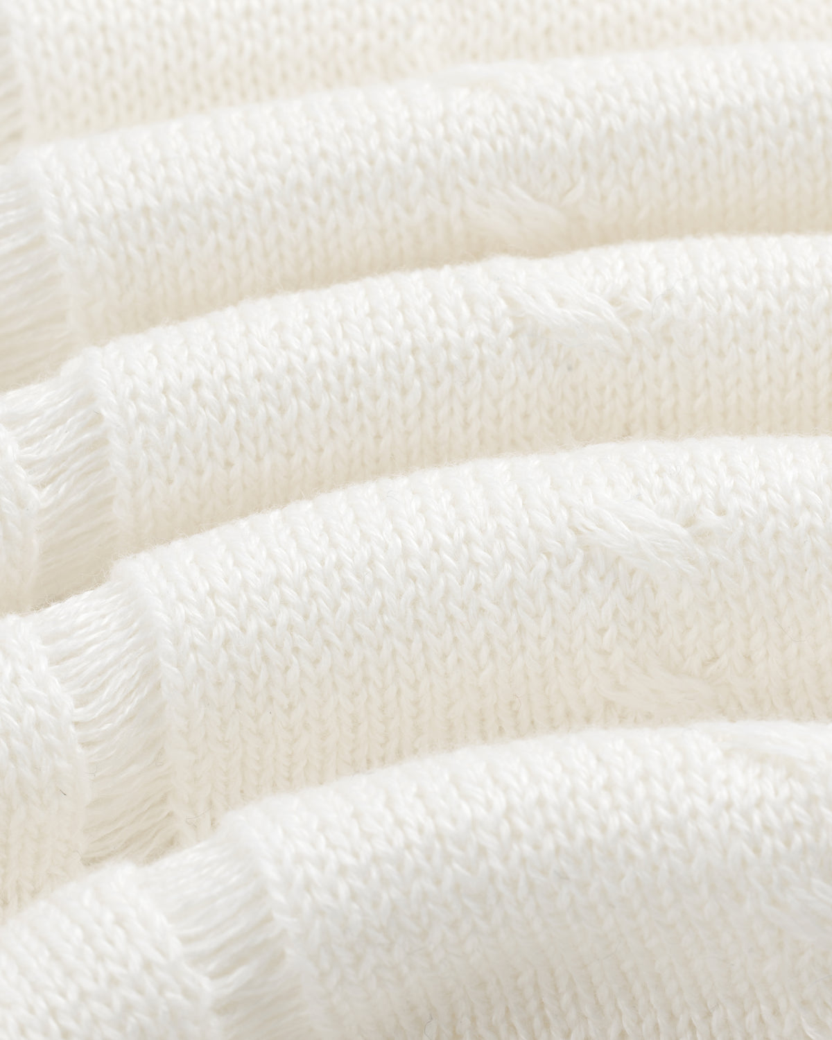 Close-up of Pointelle Tank Top's soft white knit fabric with horizontal textured ridges and loose threads.