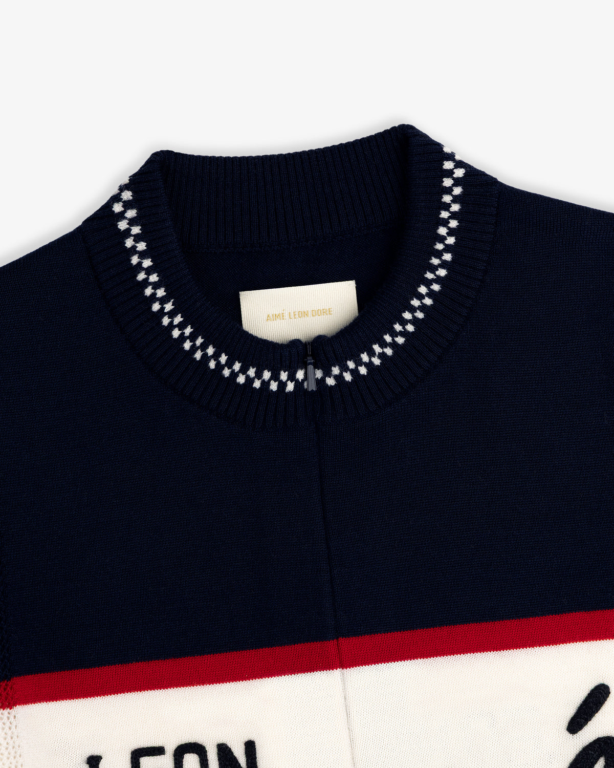 Close-up of a navy Merino Wool Cycling Jersey collar with white stitching and an Aimé Leon Dore label inside.