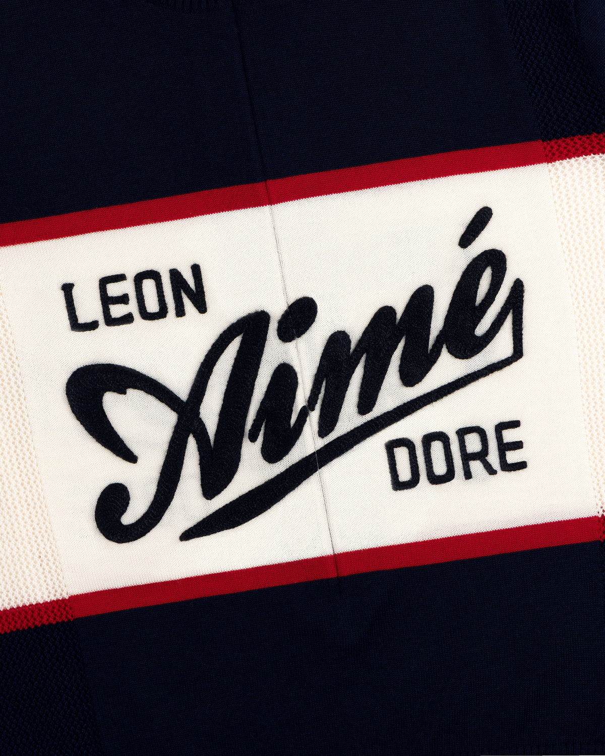 Navy Merino Wool Cycling Jersey with LEON Aimé DORE in bold white, black, and red letters, edged with red stripes.