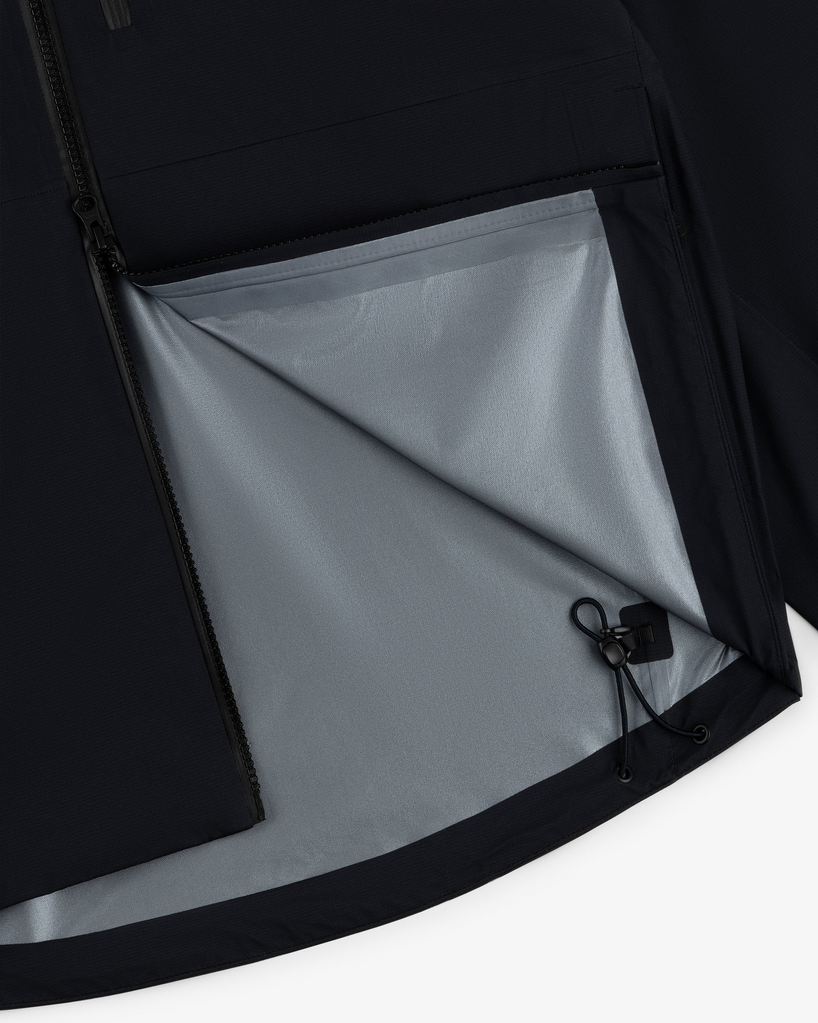 Close-up of the Lightweight GORE-TEX Shell Jacket with a partially open zipper, light gray lining, and drawstring.