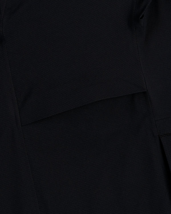 Close-up of a Lightweight GORE-TEX Shell Jacket in black, showing visible stitching and overlapping fabric layers.