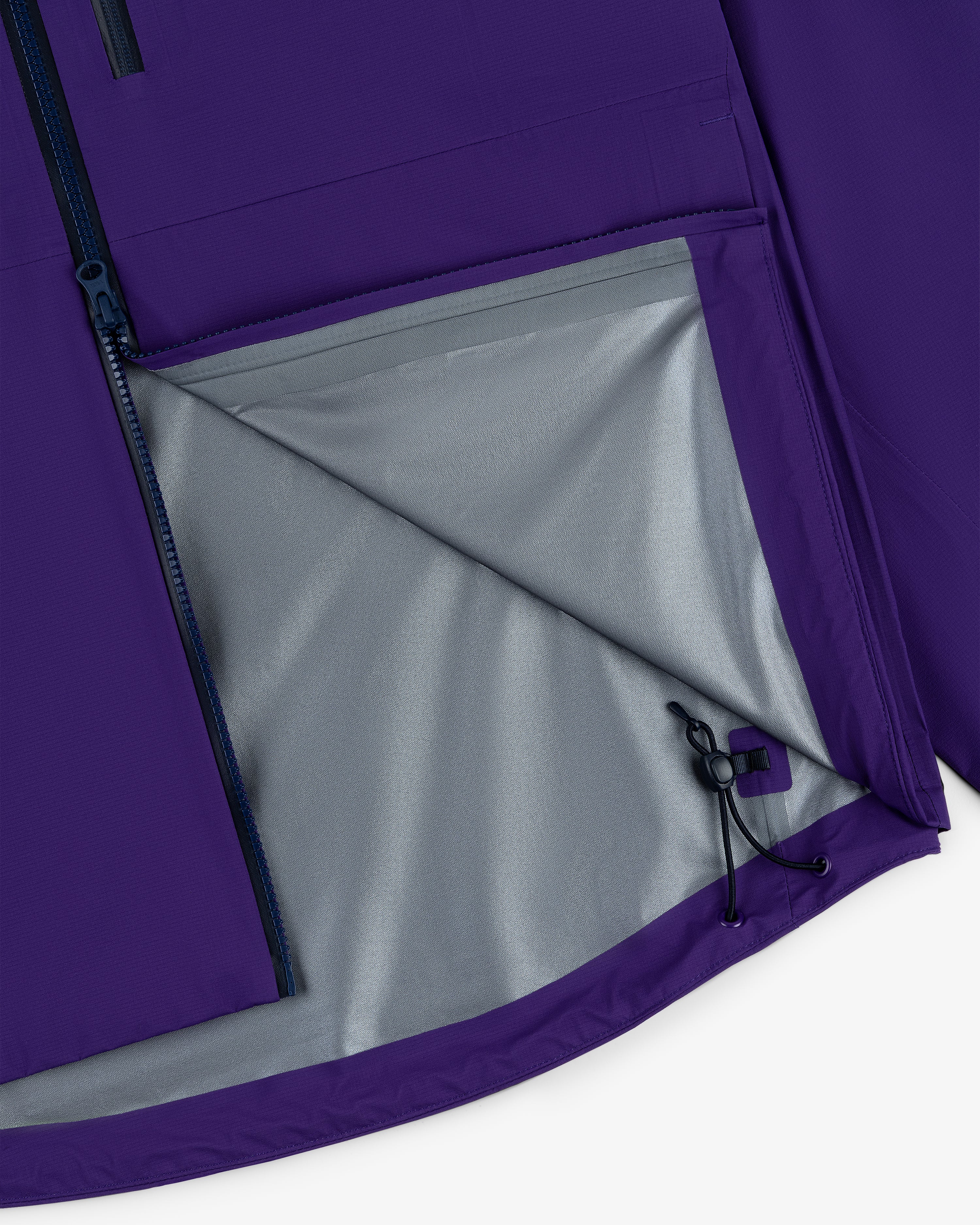 Close-up of the Lightweight GORE-TEX Shell Jacket’s purple interior pocket, grey lining, and adjustable drawstring hem.