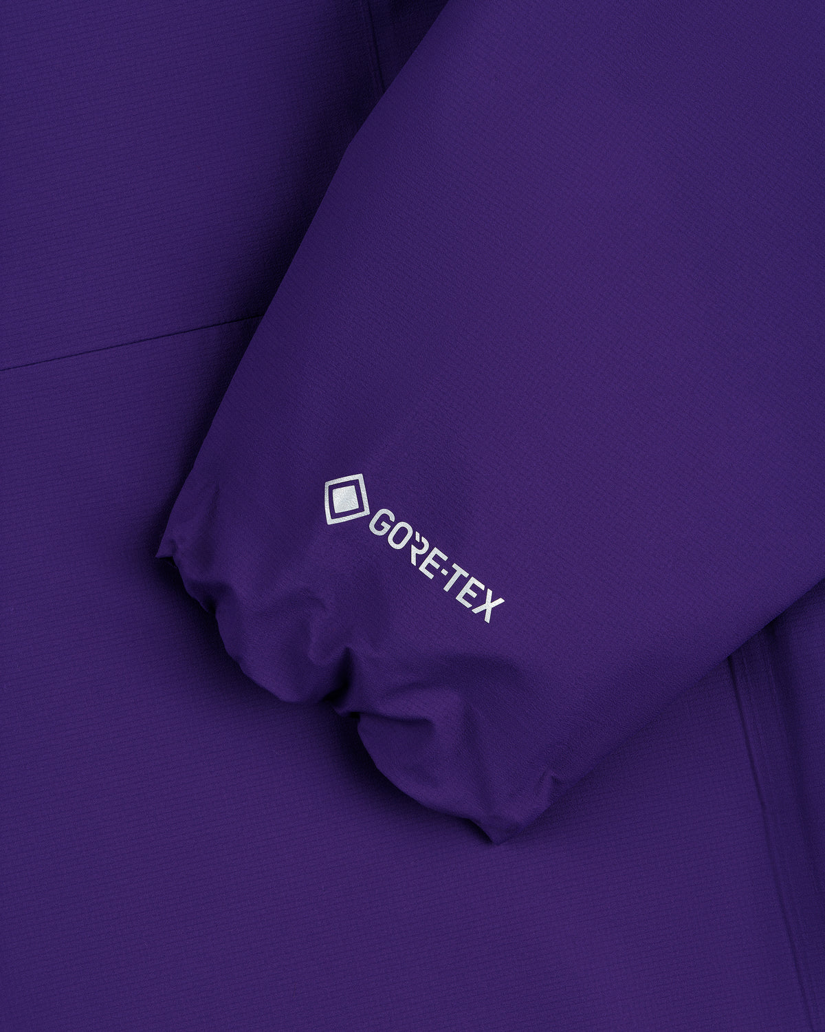 Close-up of the Lightweight GORE-TEX Shell Jacket's purple sleeve featuring a white GORE-TEX logo.